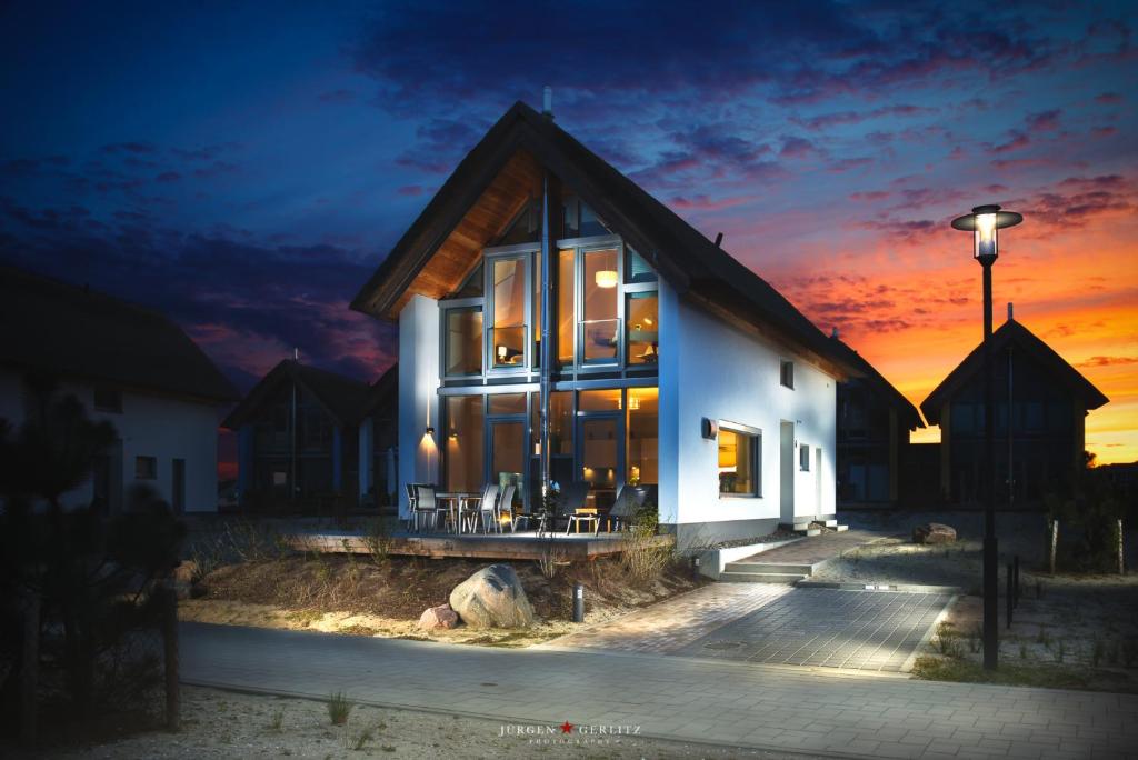 een huis wordt 's nachts verlicht bij Ostsee - Reetdachhaus Nr 13 "Reethaus am Yachthafen" im Strand Resort in Heiligenhafen