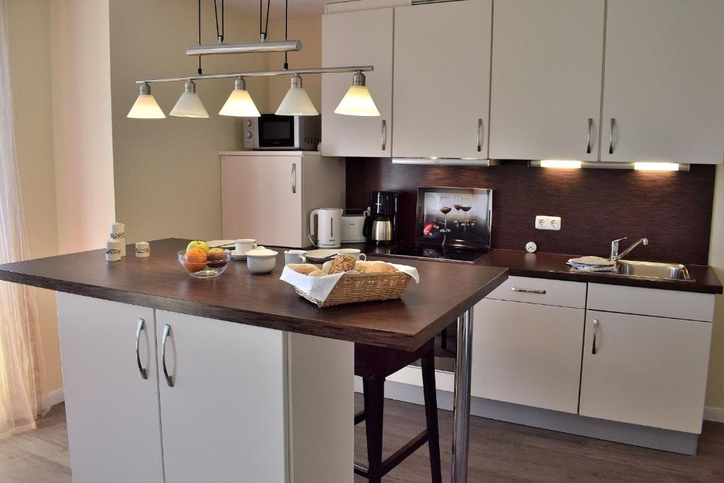 a kitchen with white cabinets and a wooden counter top at Fehmarnstrand 78 App 9 in Staberdorf