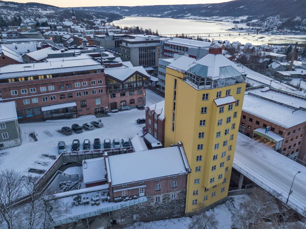 Ein gelbes Gebäude mit Schnee darauf in einer Stadt in der Unterkunft Aksjemøllen - by Classic Norway Hotels in Lillehammer