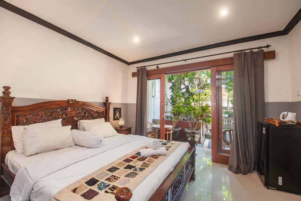 a bedroom with a bed with a chess board on it at Pondok Taksu Bali in Kuta