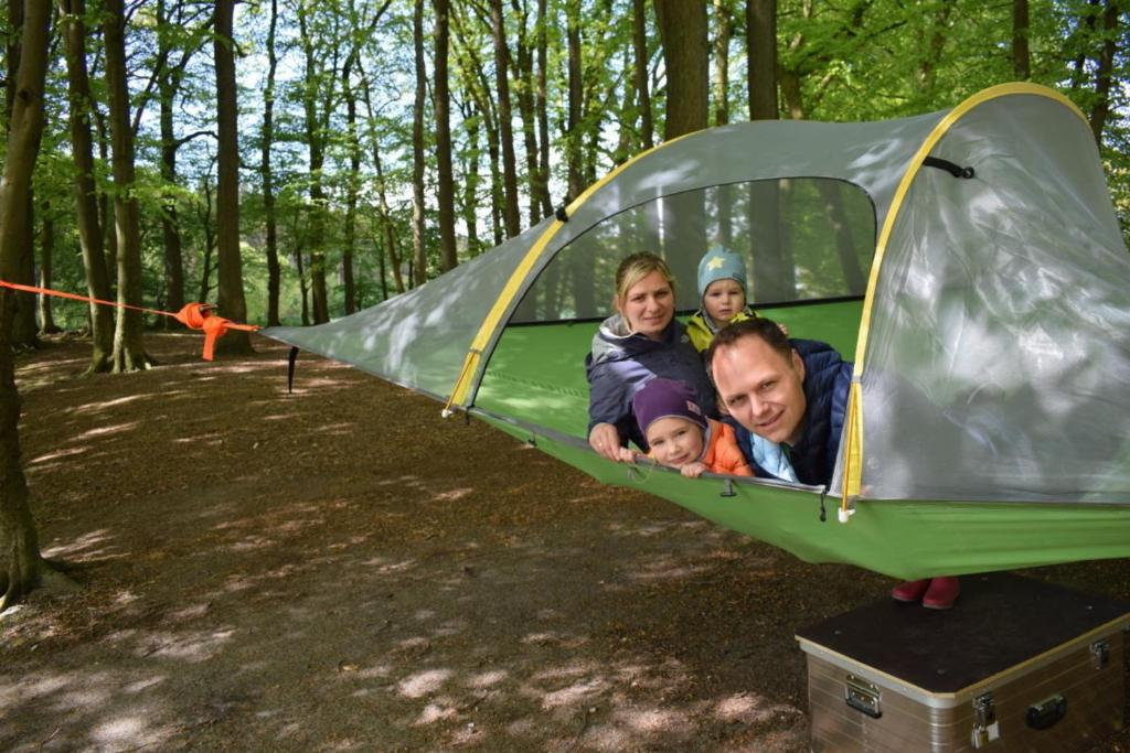 a family in a tent in the woods at Baumzelt in Wittenborn