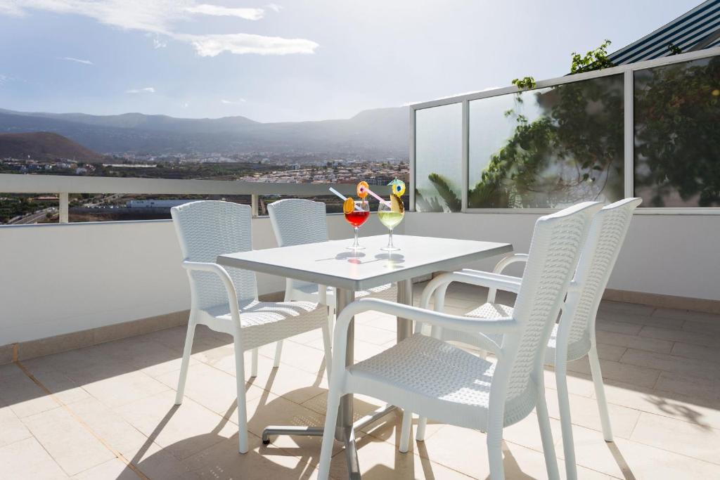プエルト・デ・ラ・クルスにあるPenthouse 1801 mit fantastischem Blick im Precise Resort Tenerifeの白いテーブルと椅子付きのバルコニー