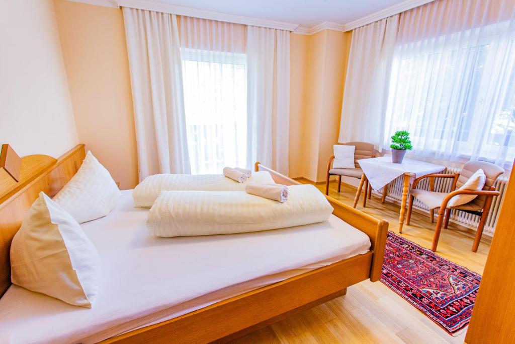 1 Schlafzimmer mit 2 Betten, einem Tisch und Stühlen in der Unterkunft Soldanella 2 by Alpenidyll Apartments in Ramsau am Dachstein