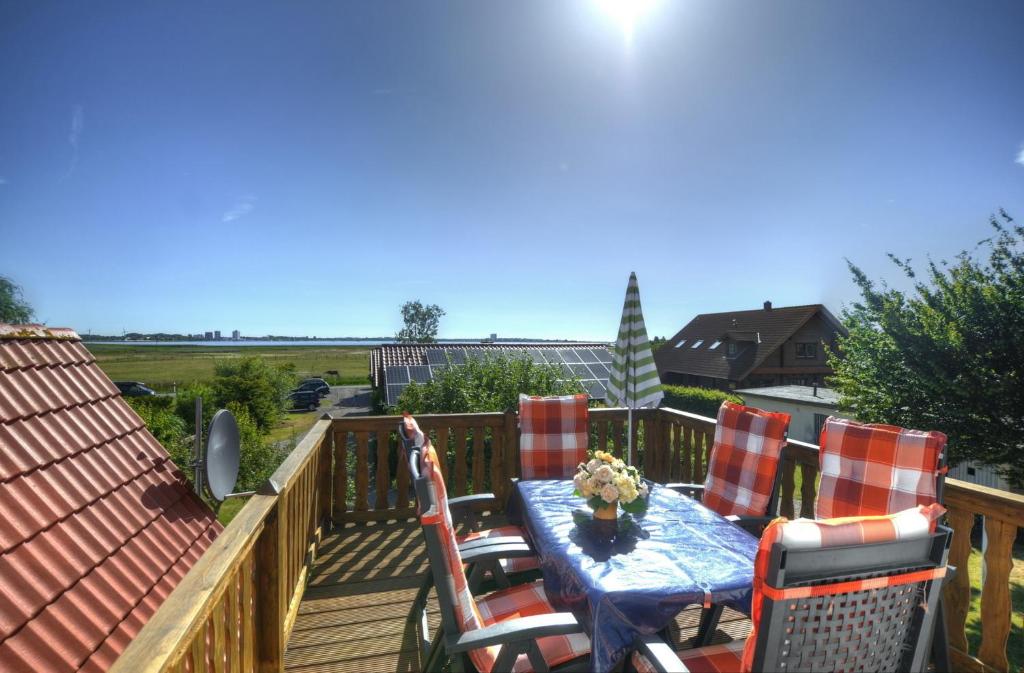 una terraza de madera con mesa y sillas. en Ferienwohnung Sewald, en Wulfen auf Fehmarn