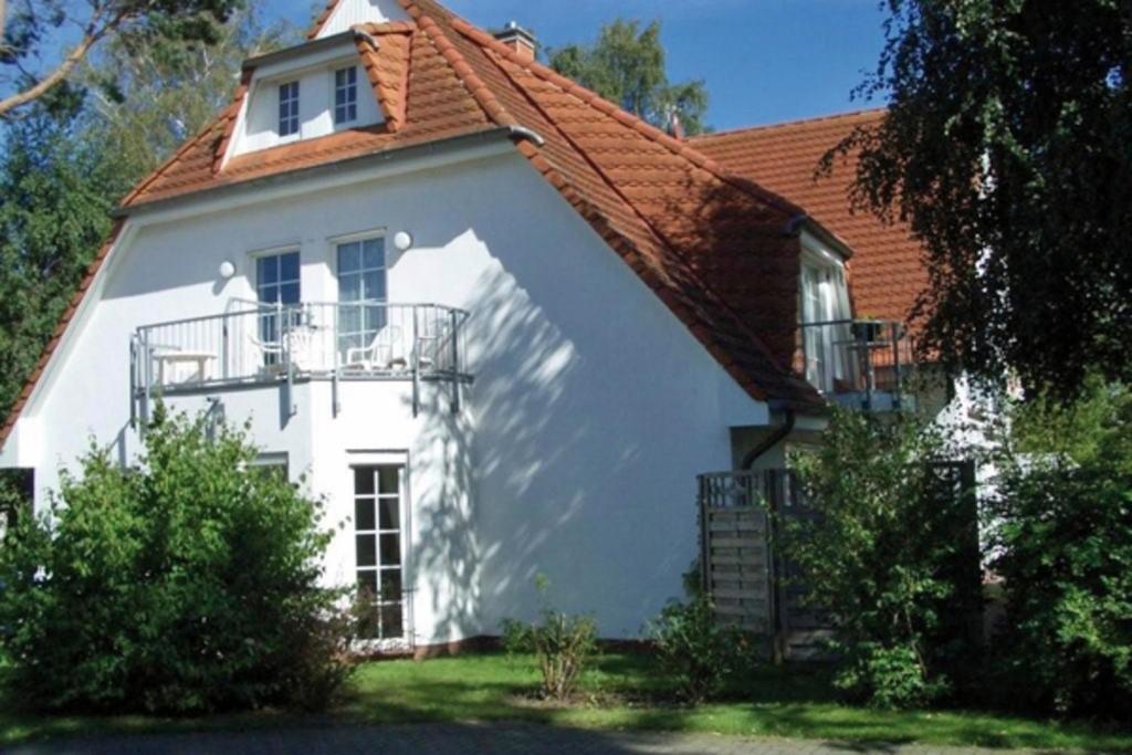 a white house with a red roof at Haus Seeschwalbe, FW 6 in Zingst