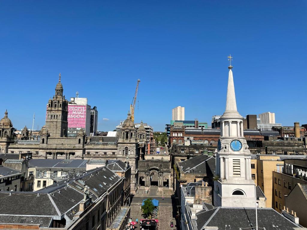 Blick auf eine Stadt mit einem Uhrturm in der Unterkunft Principal Apartments - Merchant City in Glasgow