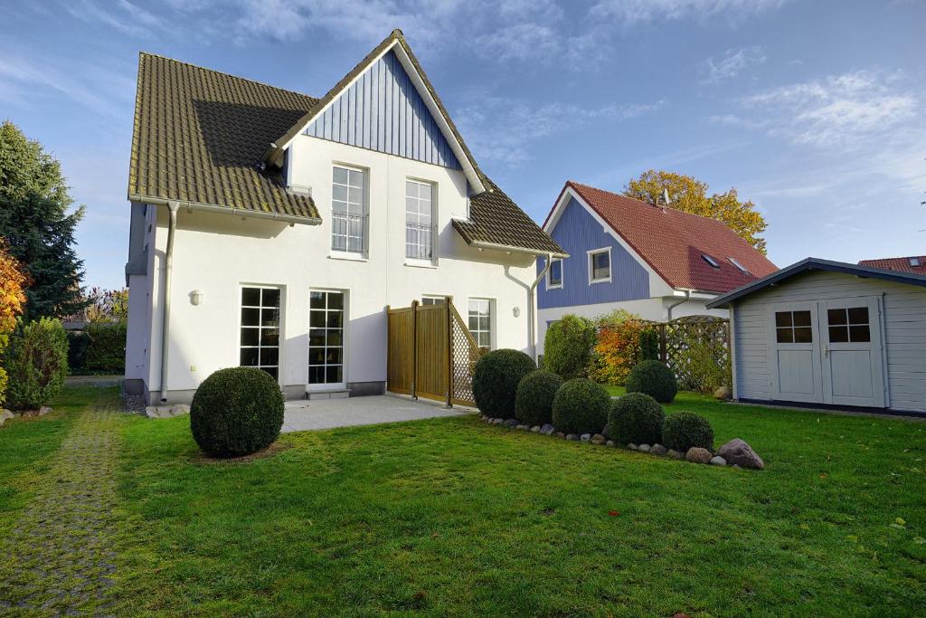 een wit huis met een hek en een tuin bij Ostseehaus 2 in Zingst