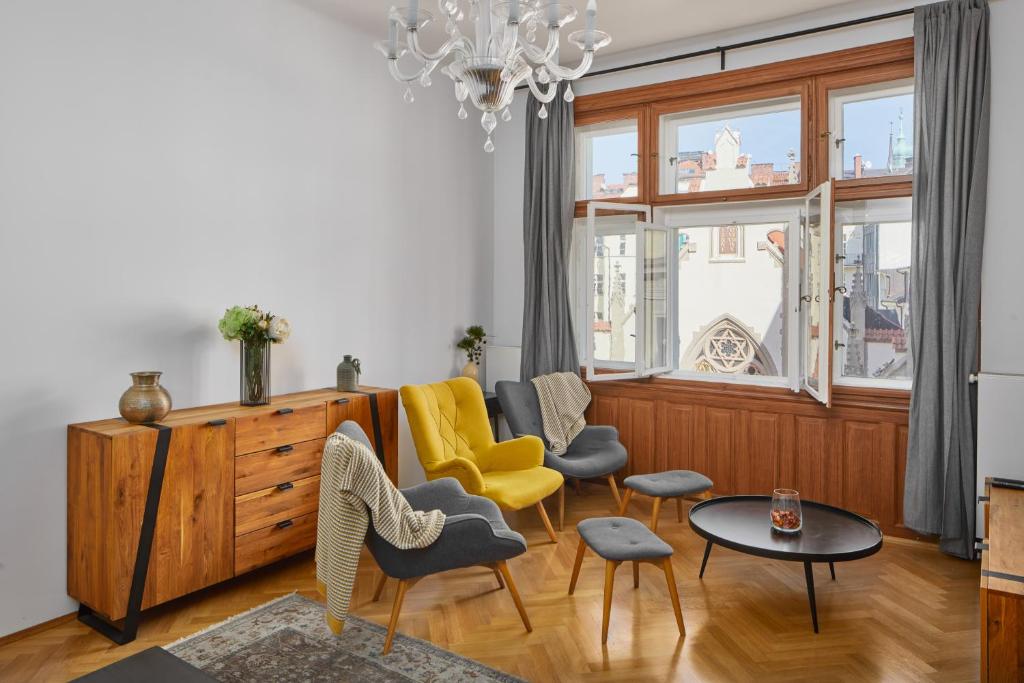 un soggiorno con sedie, tavolo e lampadario pendente di Lavish Apartment in Old Town by Prague Days a Praga