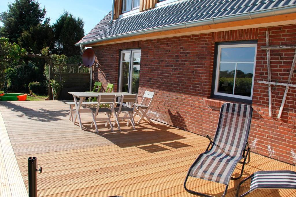 a wooden deck with a table and chairs on it at die kleine Villa in Rieseby