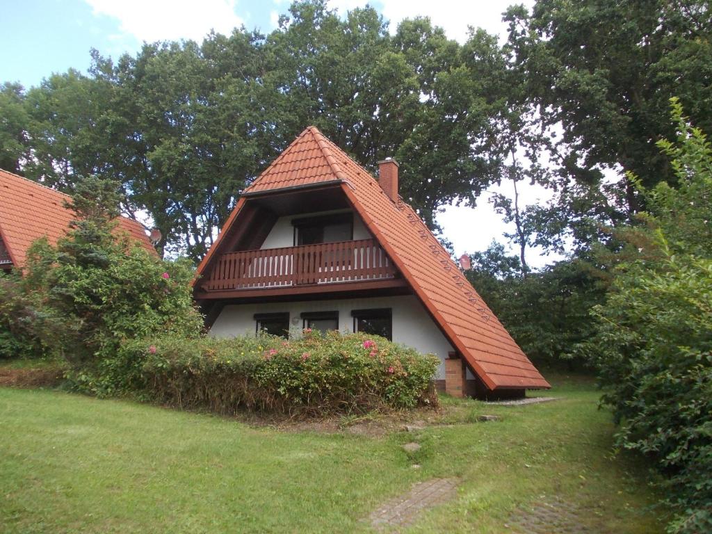 une maison avec un toit et un balcon dans l'établissement Finnhäuser am Vogelpark - Haus Brizi, à Marlow