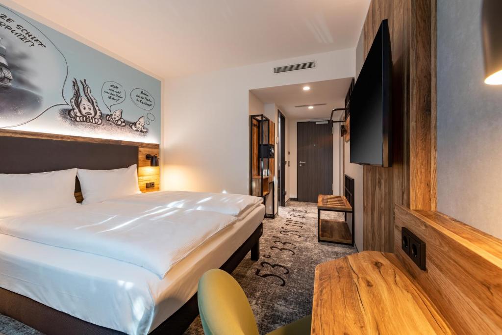 ein Hotelzimmer mit einem Bett und einem Flachbild-TV in der Unterkunft ibis Styles Hamburg Barmbek in Hamburg