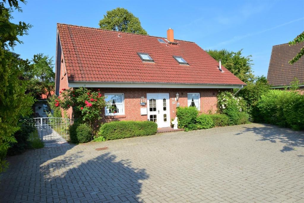 a brick house with a red roof and a driveway at Haus Antje-Kellenhusen Whg1 in Kellenhusen
