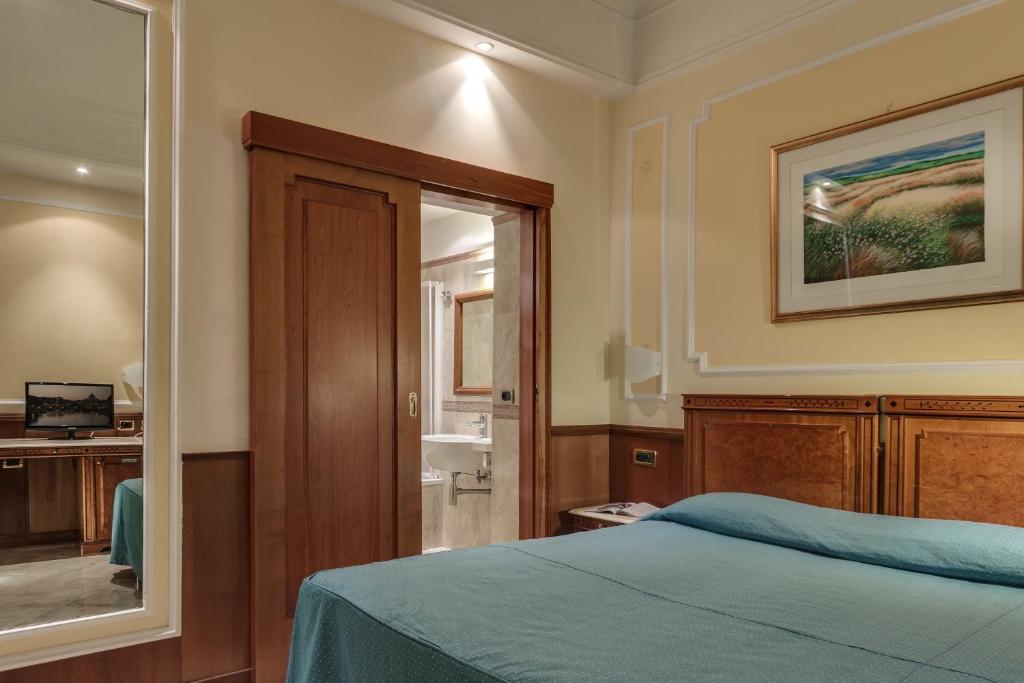Łóżko lub łóżka w pokoju w obiekcie Hotel Borromeo