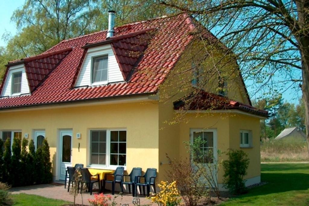 ein gelbes Haus mit rotem Dach in der Unterkunft Am Deich 13 in Zingst