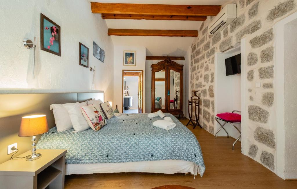 a bedroom with a bed, a desk and a painting on the wall at Auberge U n'Antru Versu in San-Gavino-di-Carbini