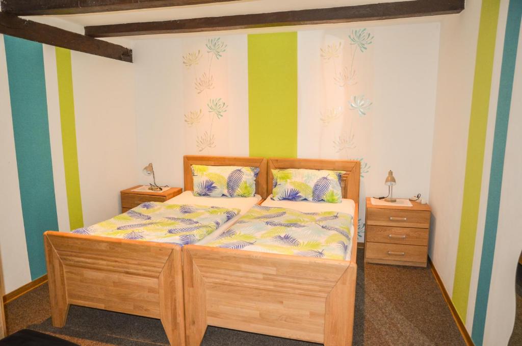 a bedroom with a wooden bed and two night stands at Ferienhof Frohne - Im Kaustall in Merzen