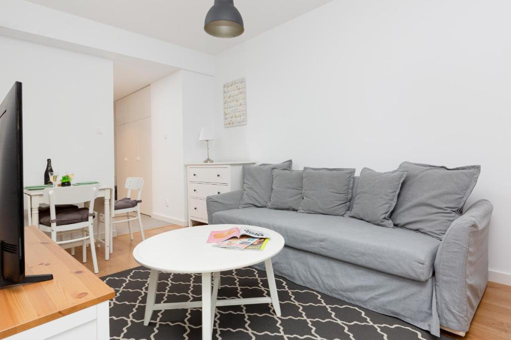 een woonkamer met een grijze bank en een tafel bij Apartments Westfield Arkadia Burakowska by Renters in Warschau