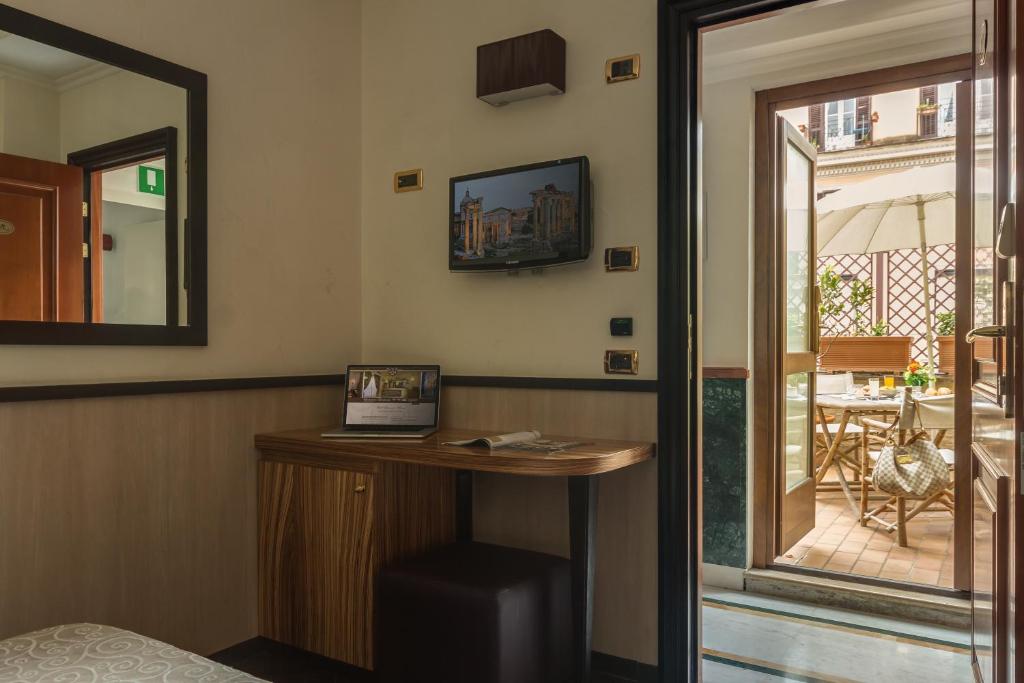 Pokój z biurkiem z lustrem i balkonem. w obiekcie Hotel Borromeo w Rzymie