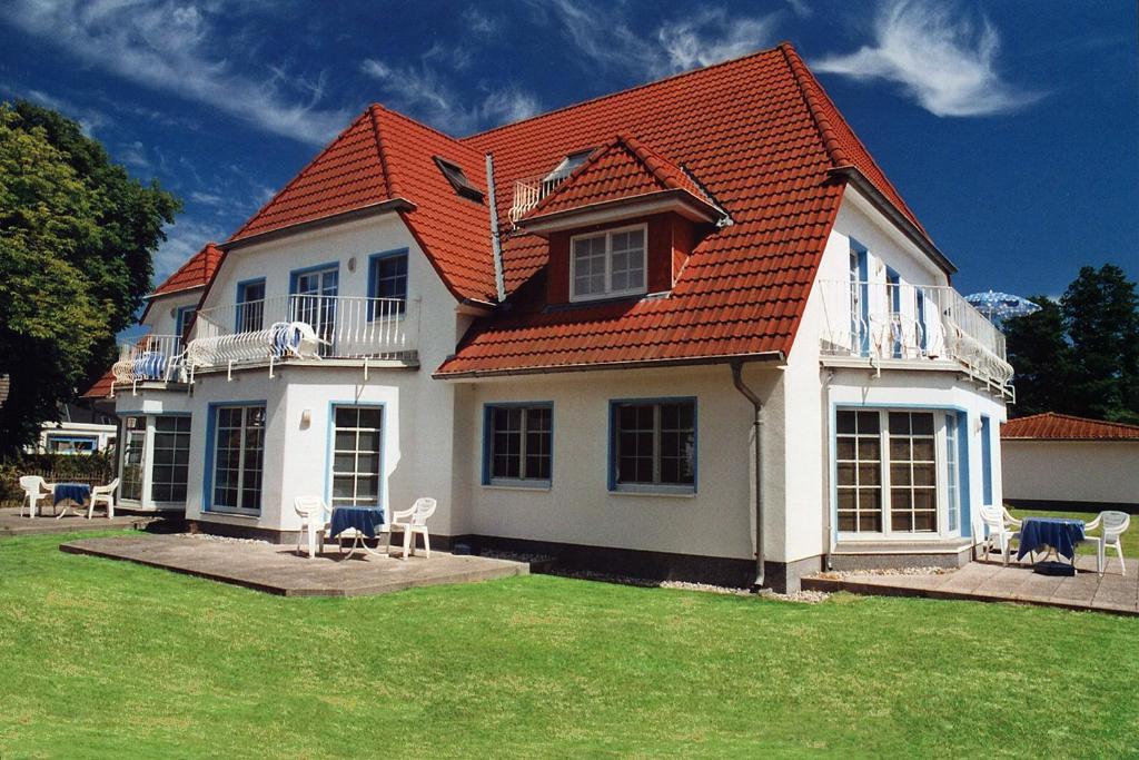 a white house with an orange roof and some chairs at An der Galerie, B 07 in Zingst