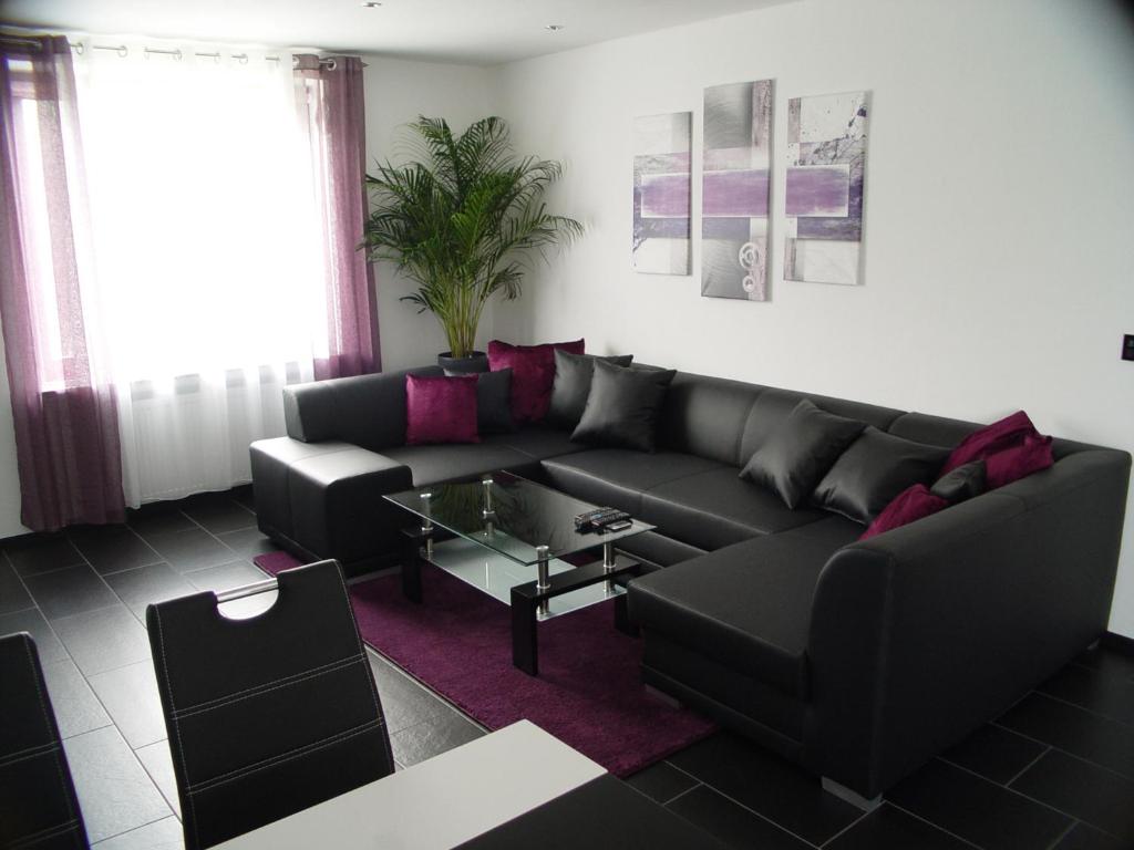 sala de estar con sofá negro y mesa de cristal en La Domus Superior en Lotte