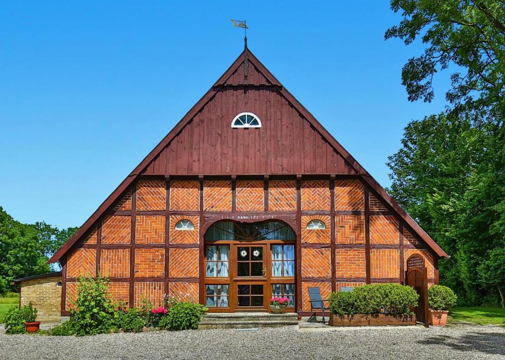 a large wooden barn with a red roof at Fachwerkhaus, Hof zur Sonnenseite Fehmarn in Sahrensdorf