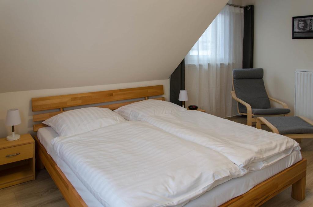 ein Schlafzimmer mit einem großen weißen Bett und einem Stuhl in der Unterkunft Ferienwohnung Herzebrock in Herzebrock