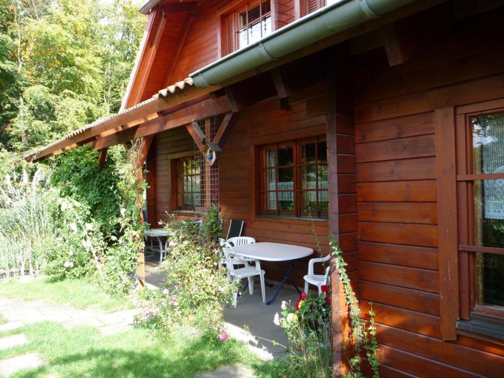 a porch of a wooden house with a table and chairs at Ferienwohnung Dehnsen in Amelinghausen