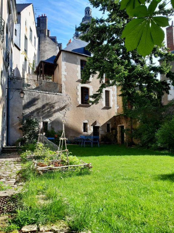 ein altes Gebäude mit einem Hof mit grünem Gras in der Unterkunft Suite 2 - Les Grands Degrés Saint Louis in Blois