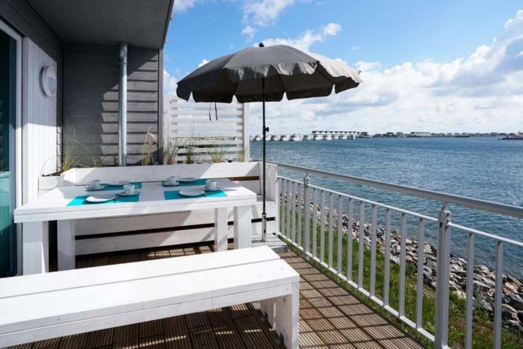 a balcony with a table and an umbrella at Marina Villa in Kappeln