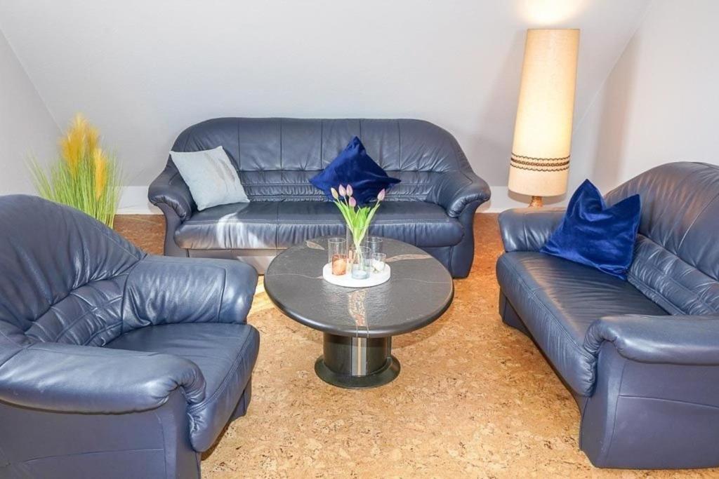 ein Wohnzimmer mit 2 Sofas und einem Tisch mit blauen Kissen in der Unterkunft Ferienwohnung Schneider in Bannesdorf
