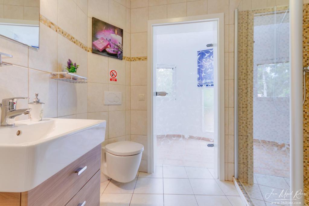 een badkamer met een wastafel, een toilet en een douche bij Sobre de Granadella Haus 3 in Jávea