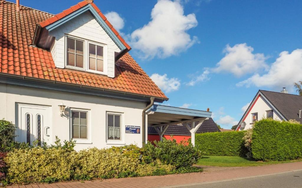 une maison blanche avec un toit orange dans l'établissement Deichweg 8, à Zingst