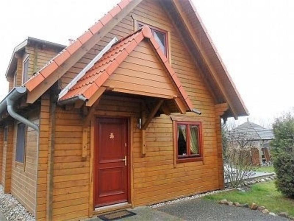 a small wooden house with a red door at Ferienhaus Bliev-Hee Nr 2 in Klink