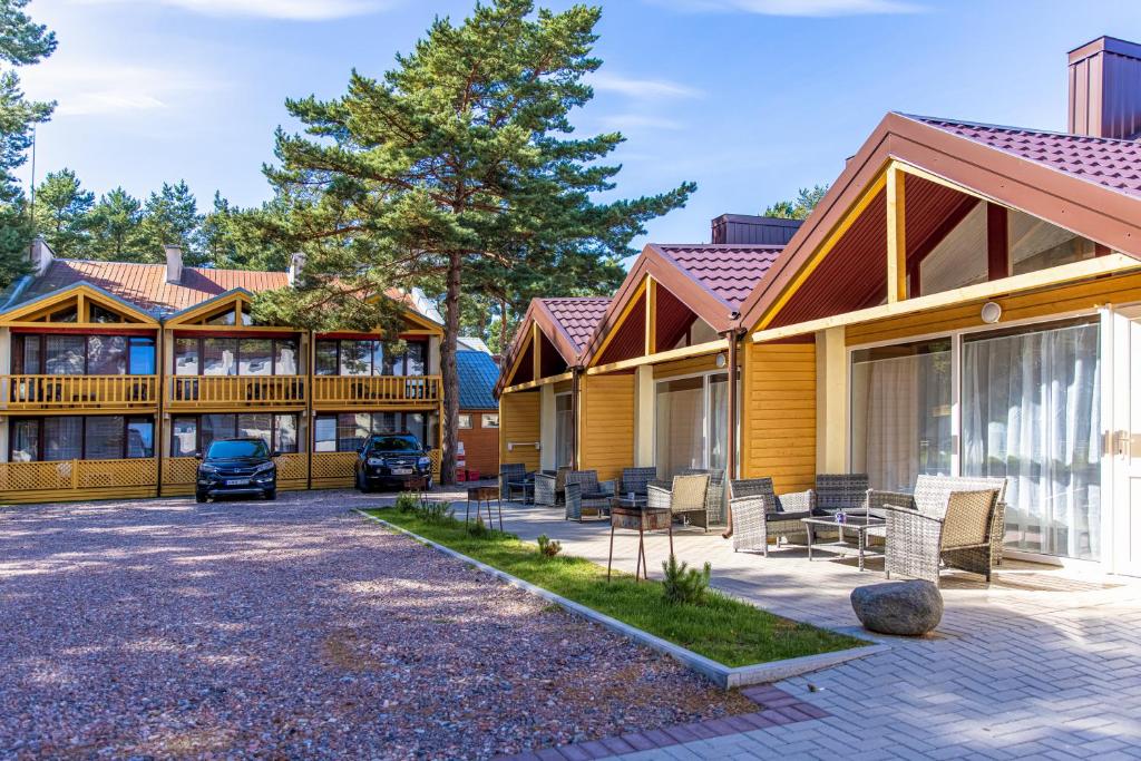 une maison avec une terrasse et un patio dans l'établissement Poilsio namai Banga Sventojoje, à Šventoji