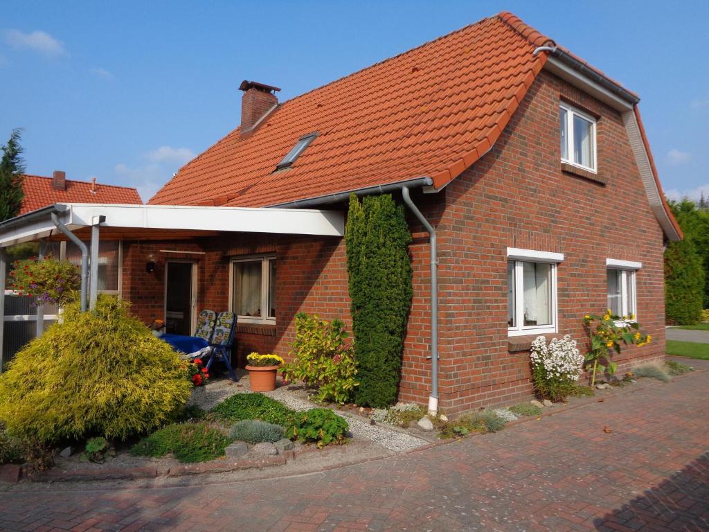 een bruin bakstenen huis met een oranje dak bij Ferienwohnung Familie Renken in Marienhafe