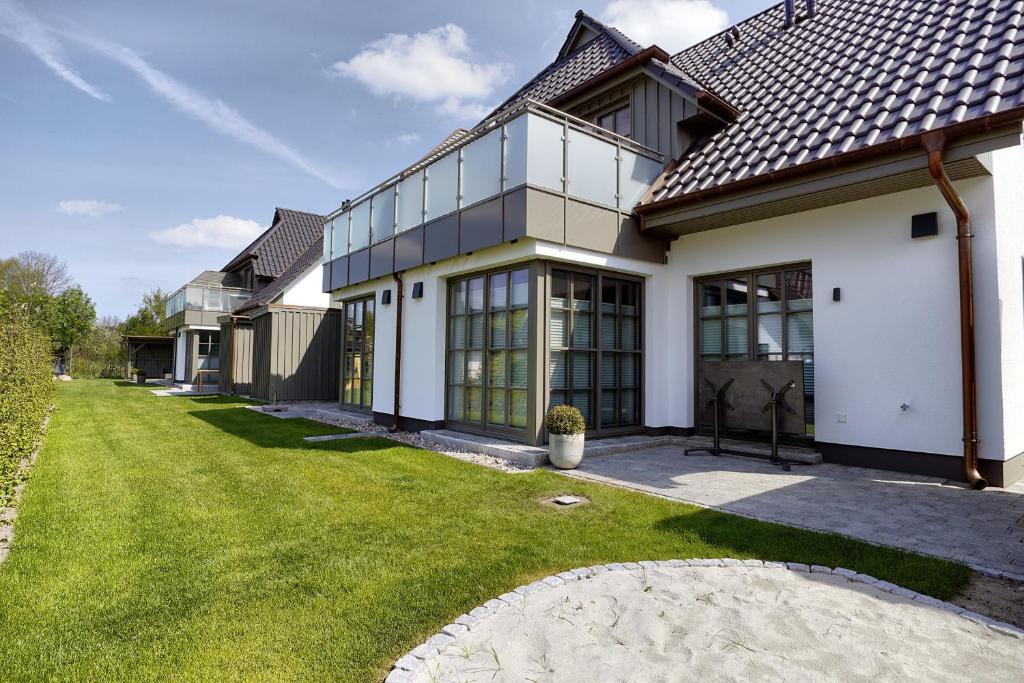a house with a green lawn in front of it at Sanya in Zingst