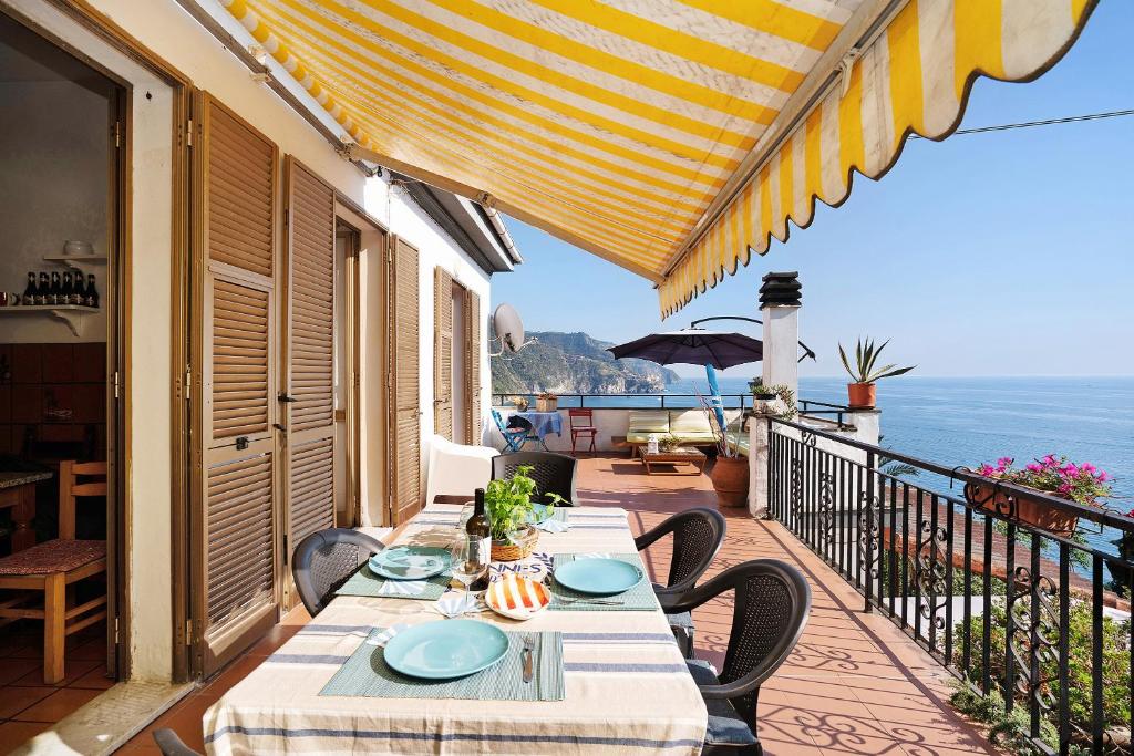 a table on a balcony with a view of the ocean at Villa Lardarina in Corniglia