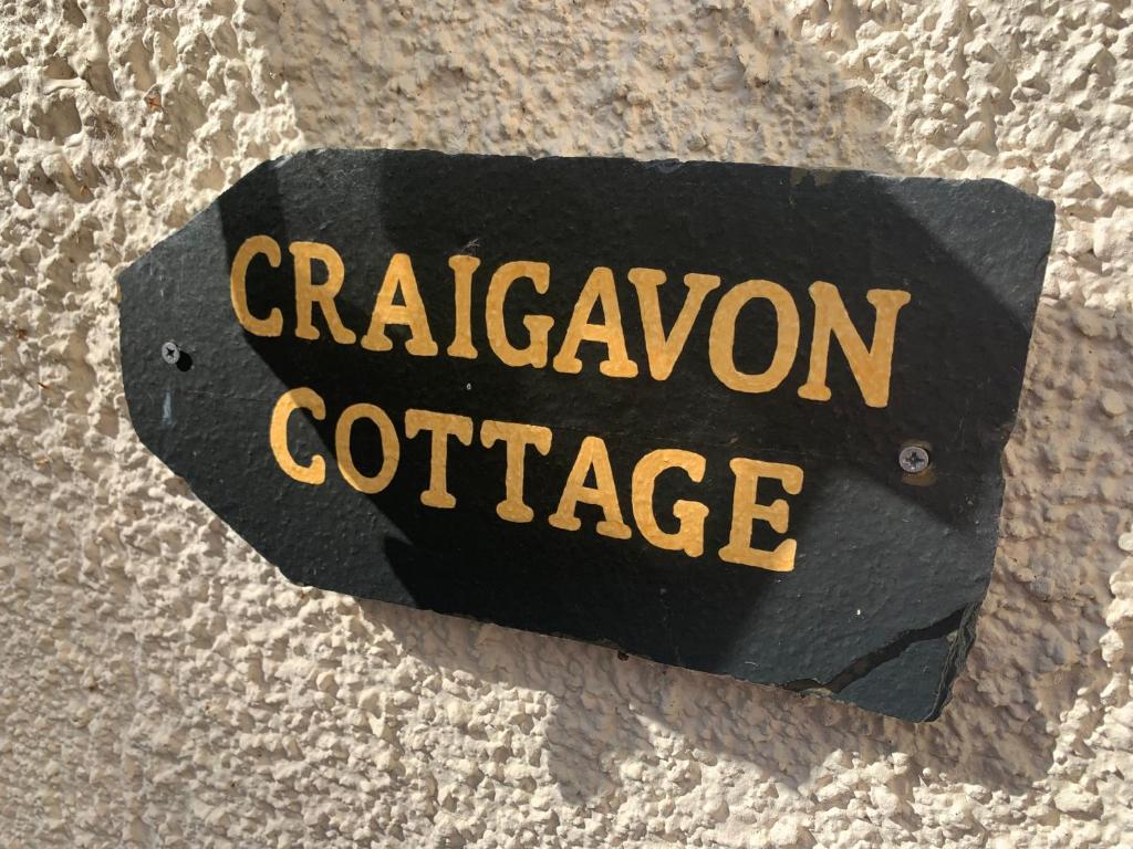 un panneau qui saysagonise sur le côté d’un mur dans l'établissement Craigavon Cottage, à Ballachulish