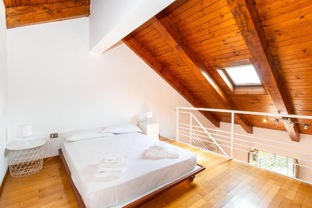 a bedroom with a white bed and wooden ceilings at Central&Lovely Savoia Loft in Turin