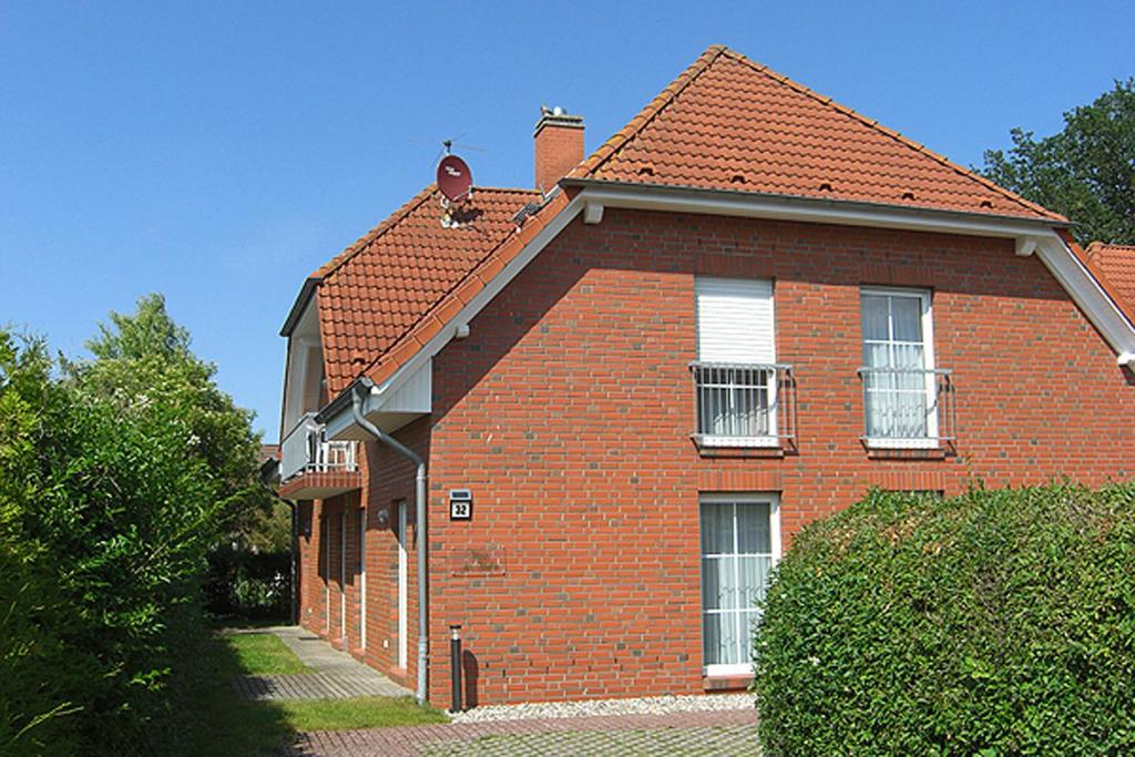 a red brick house with two windows and a roof at Haus am Hafen Boddenzauber FW 4 in Zingst