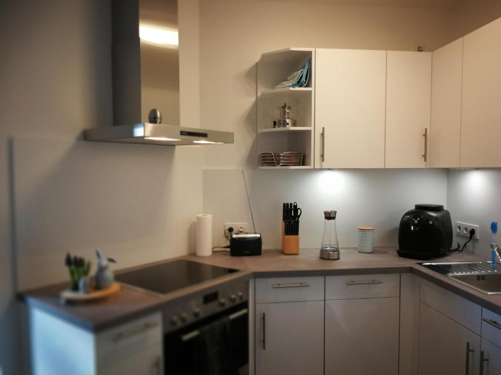 Komfort-Wohnung 03 FehmarnBrise في بورغ أوف فيهمارن: مطبخ بدولاب بيضاء وقمة كونتر