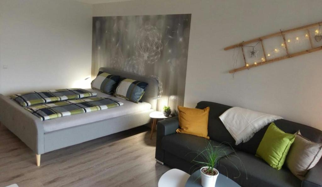 ein Wohnzimmer mit einem Bett und einem Sofa in der Unterkunft See Harmonie Haus 4 Jahreszeiten in Hahnenklee-Bockswiese