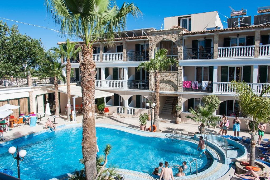 a view of a hotel with a pool and palm trees at Zante Plaza Hotel & Apartments in Laganas