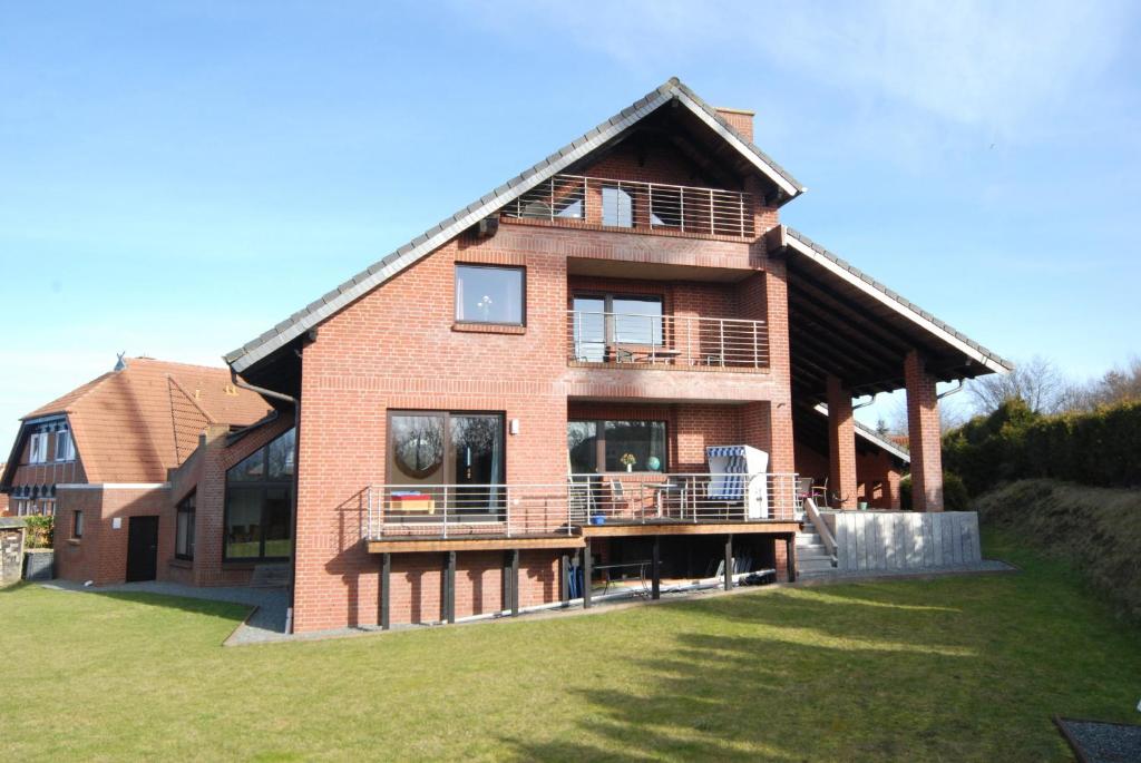 a large brick house with a porch and a balcony at Ferienwohnung Leuchtturm in Heiligenhafen