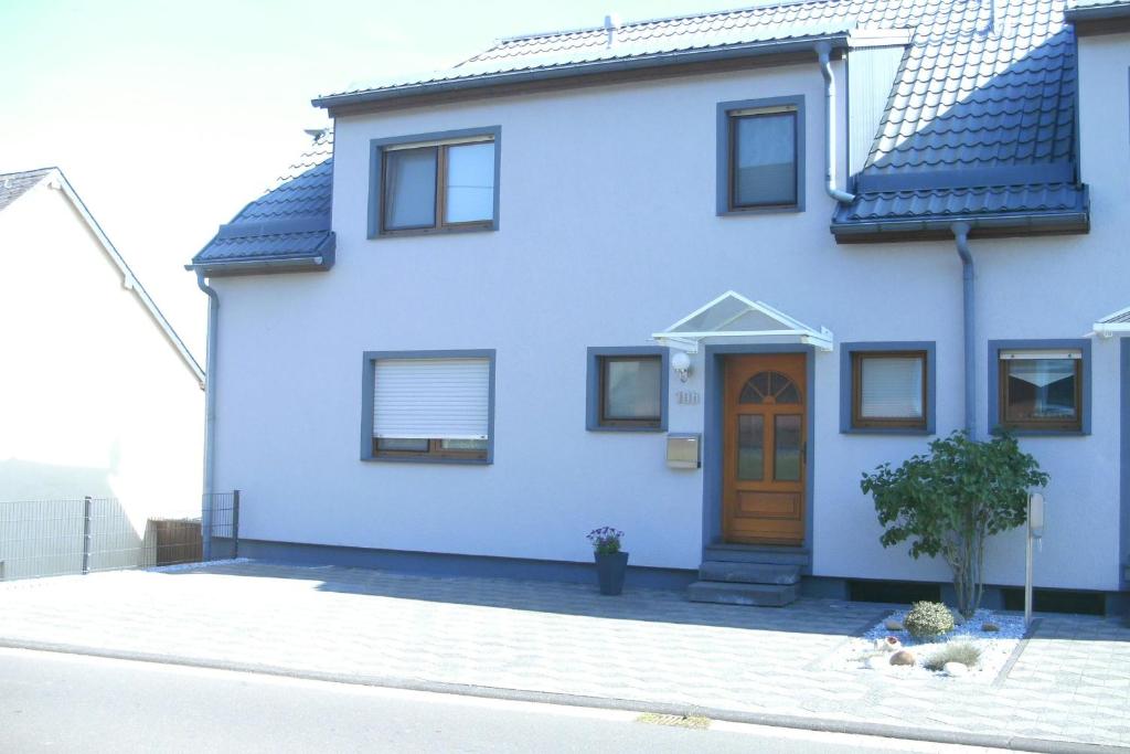 een wit huis met een bruine deur op een straat bij Ferienhaus Helten in Lützkampen