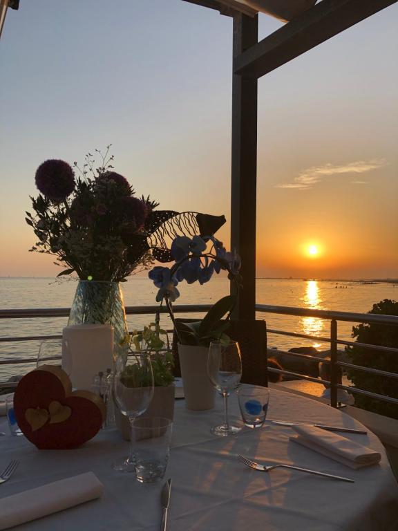 a table with a view of the ocean at sunset at Hotel Marea in Grado