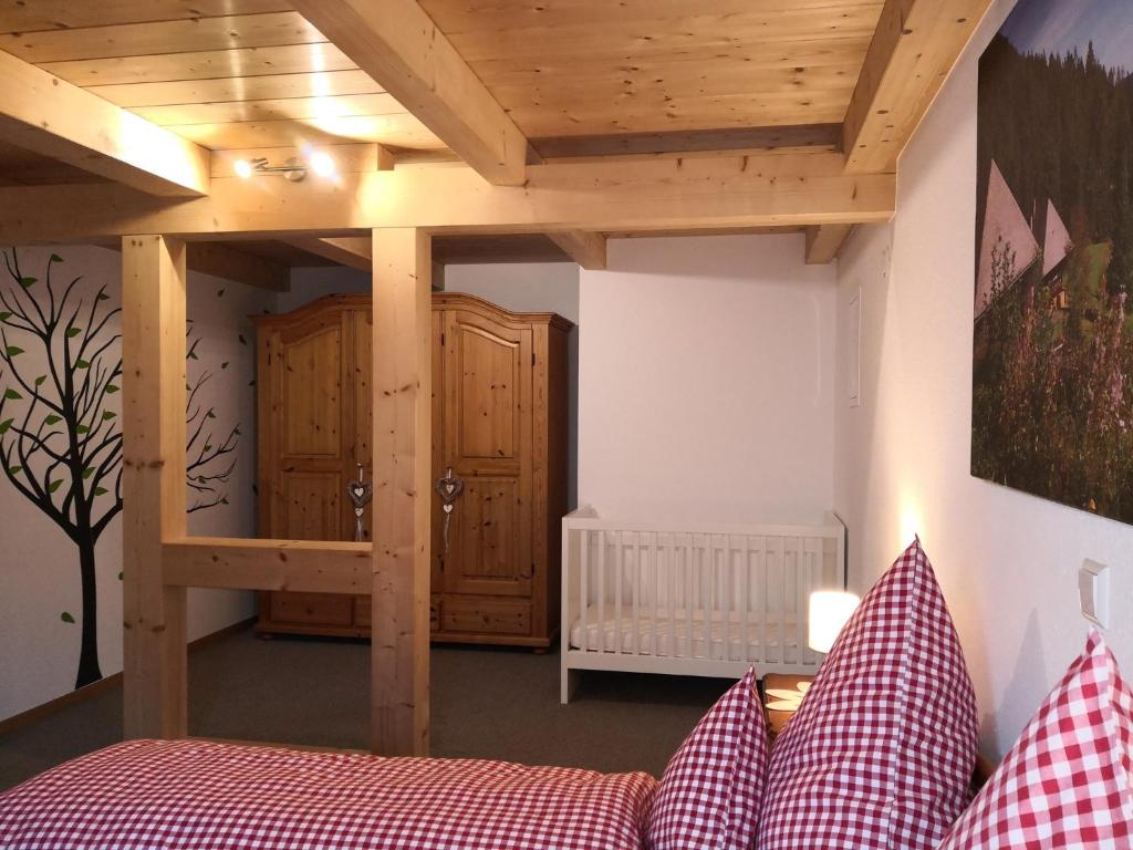 Schlafzimmer mit einem Bett und Holzdecken in der Unterkunft Ferienwohnung Belchenliebe in Schönenberg