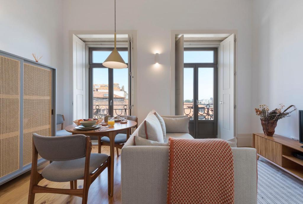 a living room with a table and chairs and a dining room at Tripas Coração Taipas Historical Center in Porto