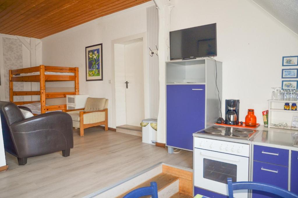 eine Küche mit einem blauen Kühlschrank und ein Wohnzimmer in der Unterkunft Ferienhof Frohne - Spielzimmer in Merzen