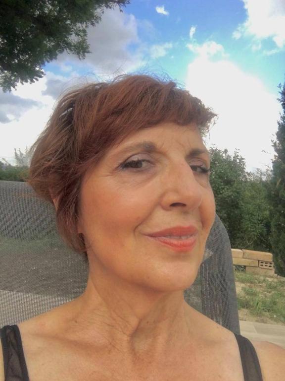 une femme aux cheveux courts souriant à la caméra dans l'établissement Les Treillettes, à Puylaurens